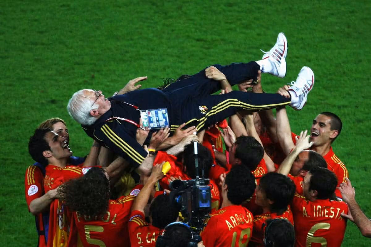 Spain players throw Luis Aragones into the air